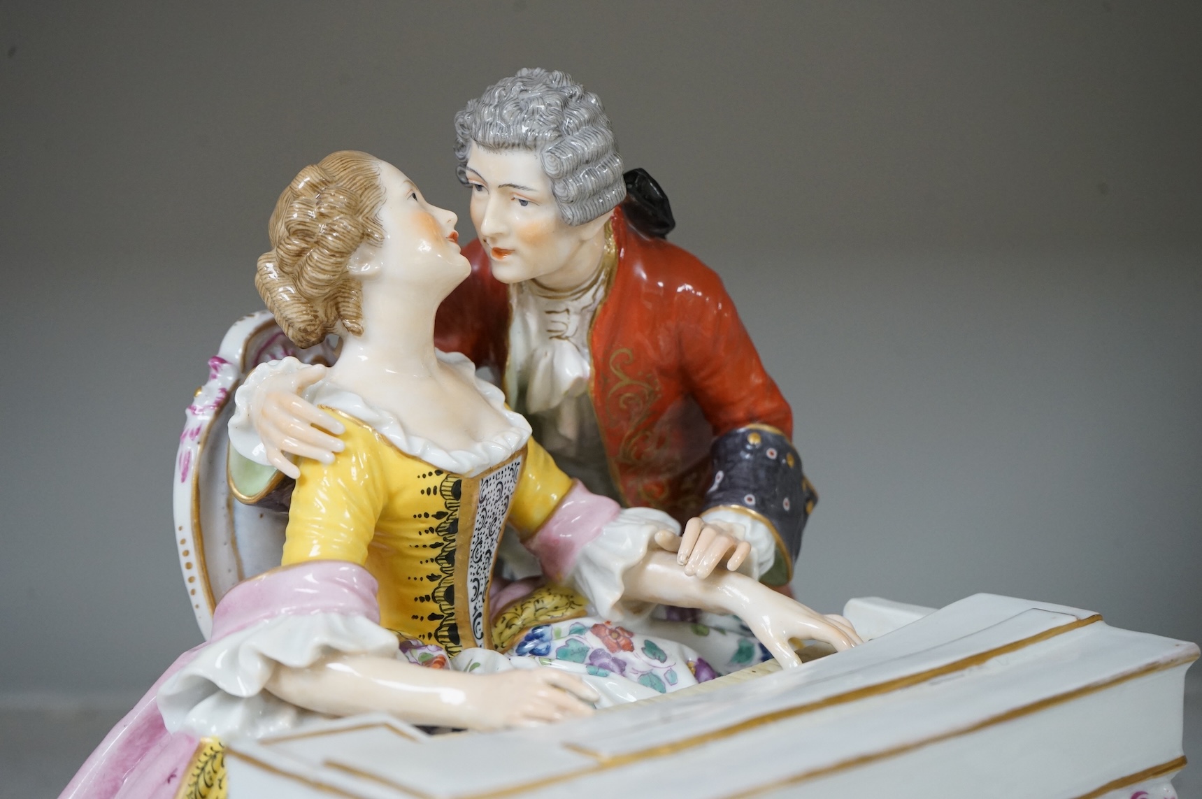 A large German porcelain group lovers at a piano, 22cm high